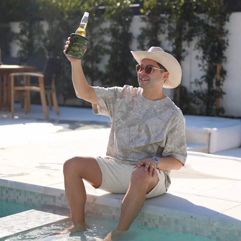 Man sitting by pool, holding Wrapsulator Regular in Camouflage style